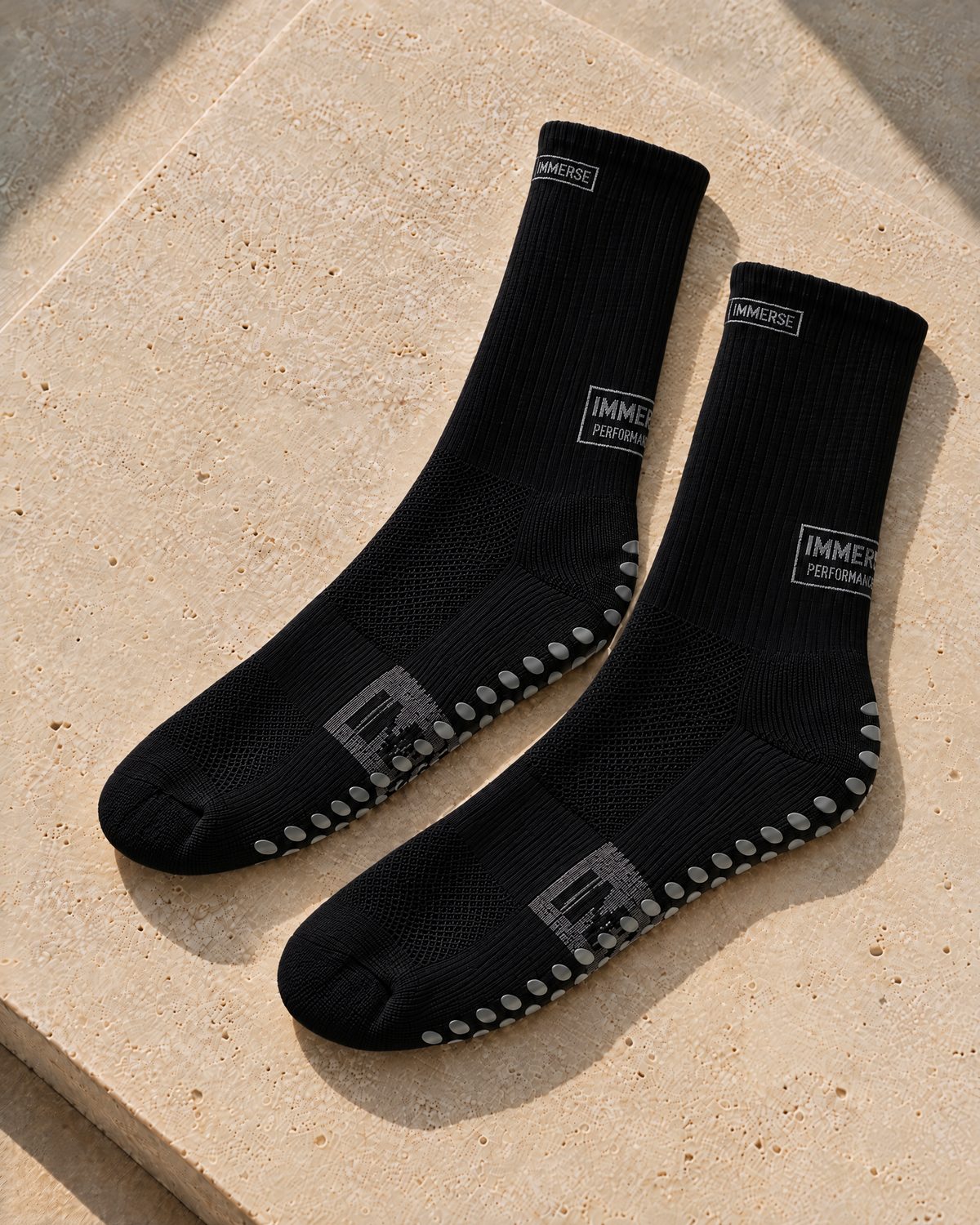 Immerse GRIP Crew Black, real product, laid on travertine