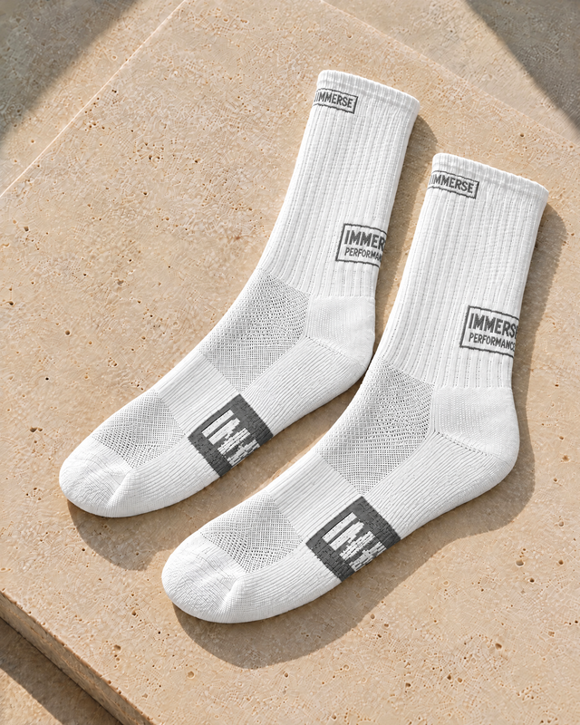 Immerse Crew Daily White, a pair laid on a travertine slab